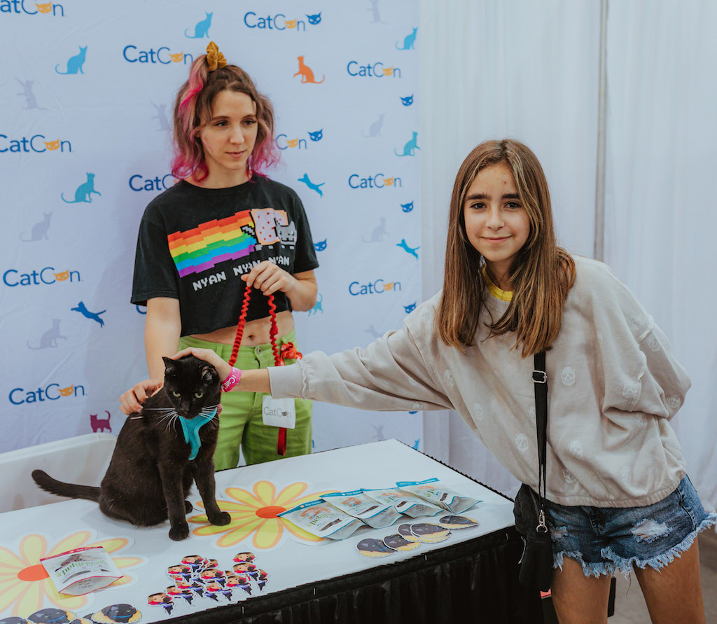 One eared Uno, Kat Curtis, and a fan at CatCon 