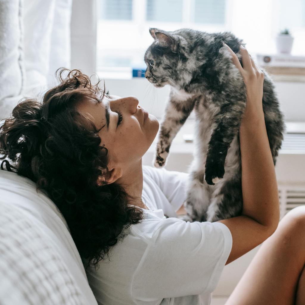 Woman looking adoringly at a grey cat